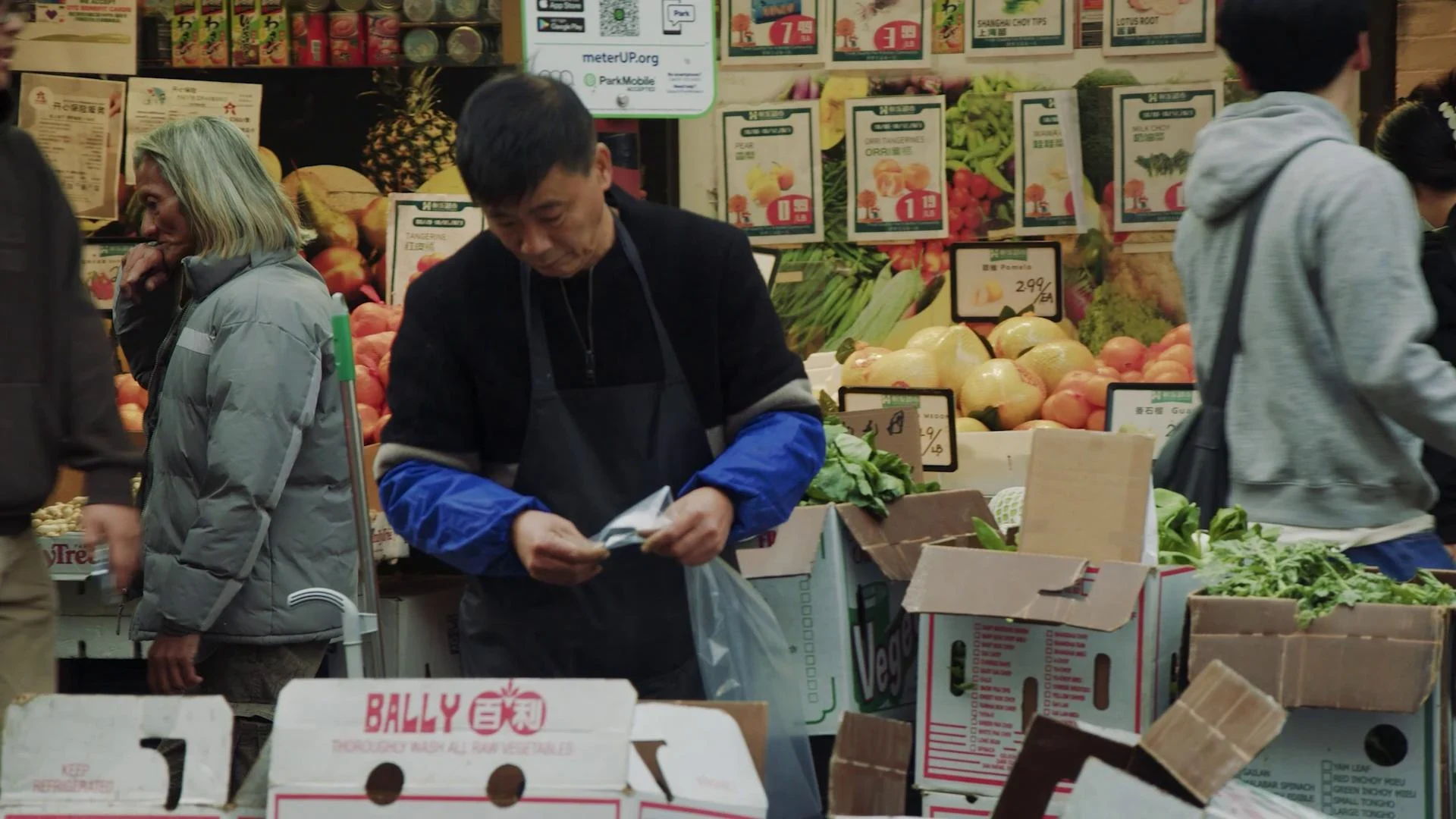 A produce seller in a Chinatown market