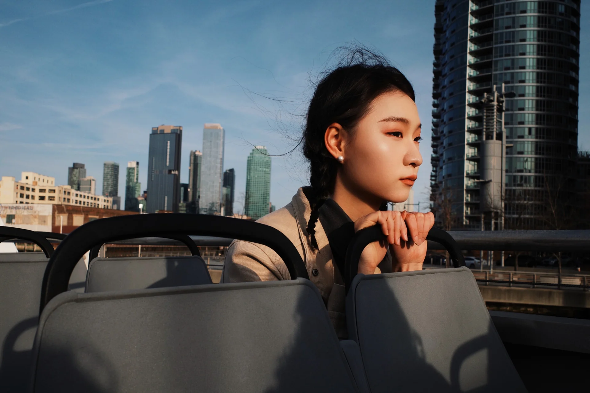 Portrait against a city skyline, reflected in a car mirror